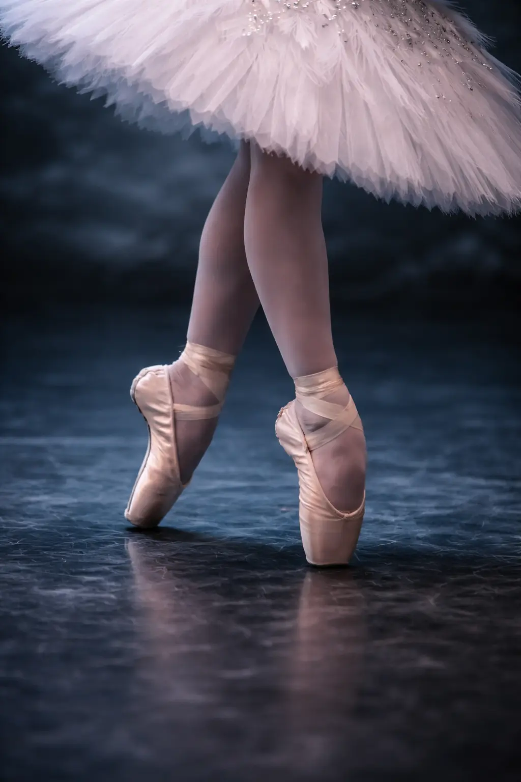 Pies de bailarina de ballet en puntas con zapatillas rosadas sobre el escenario, captando la técnica y elegancia de la danza clásica.